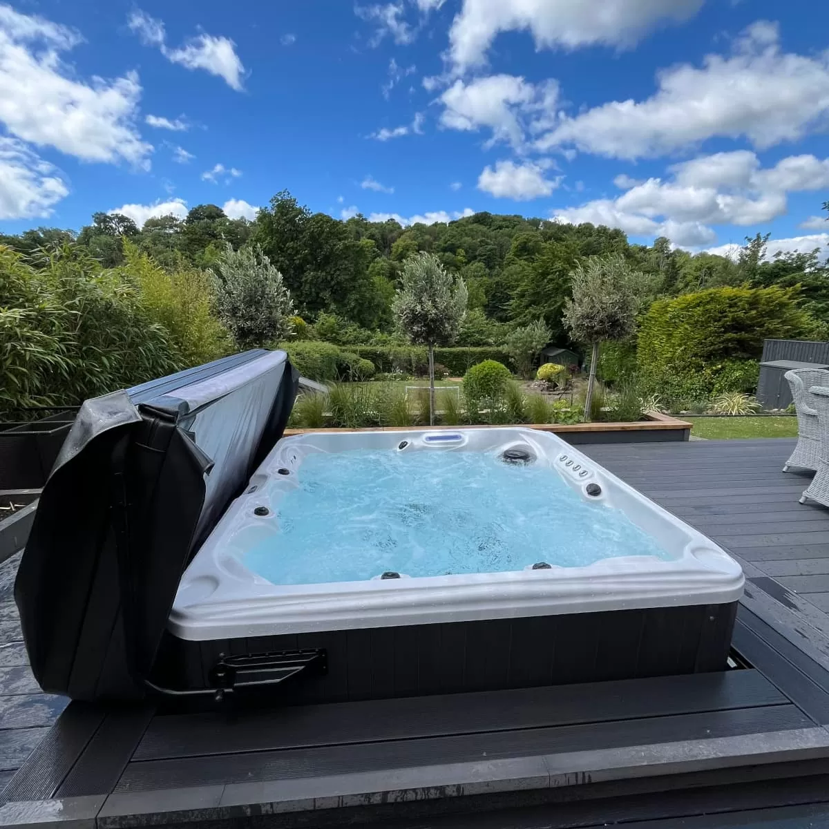 Hot Tub with blue skies and woodland backdrop